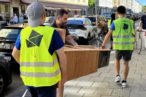 Students are building up a parklet with wood and plants.